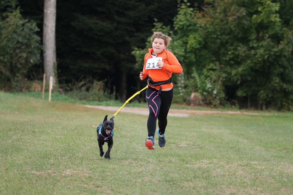jeune fille fait du canicross avec son chien noir